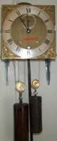 The face and mechanism of a brass longcase clock
